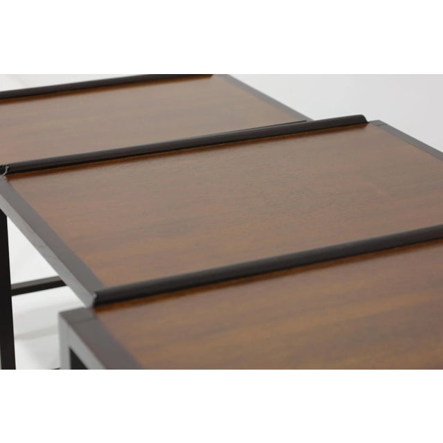 Enhance your living space with this beautiful set of nesting tables Attributed to Dunbar, featuring elegant walnut tops...
