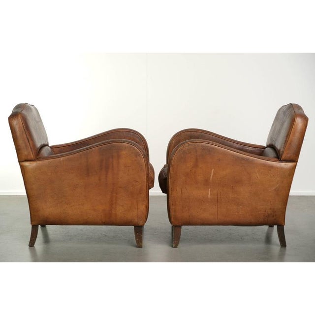 This rugged yet comfortable set of 2 vintage sheepskin armchairs has a great industrial look. The armchairs feature loose...