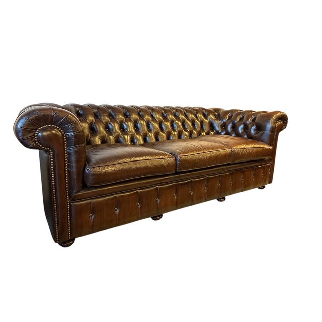 Vintage Chesterfield sofa upholstered in brown leather with a beautiful natural patina.Crafted in the late 20th century. A...