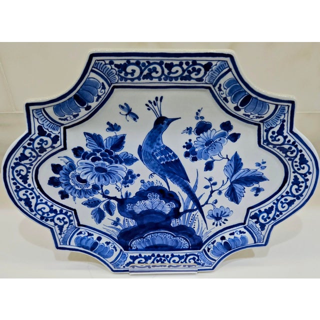 Hand-painted Royal Delft blue and white wall plaque featuring a bird and floral motif, produced by De Porceleyne Fles in...