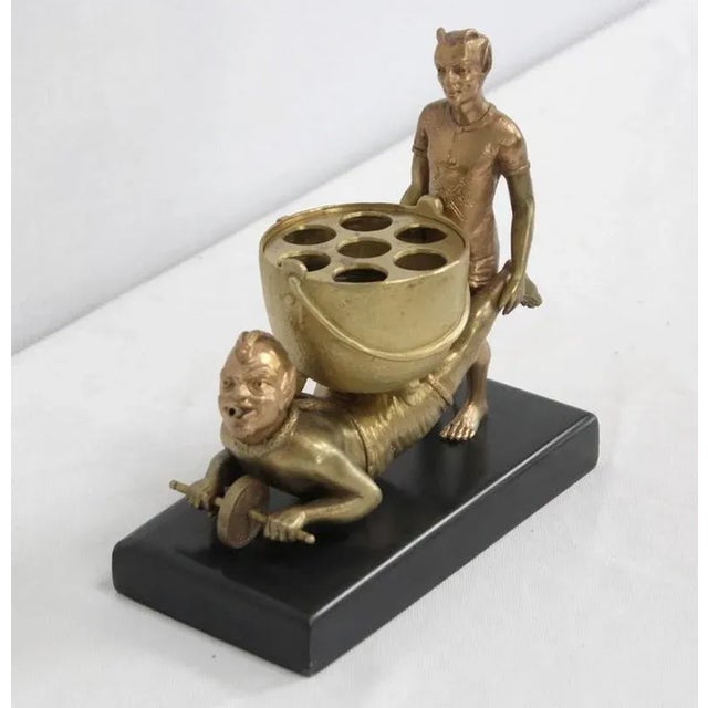 Bronze with golden patina representing two imps, resting on a black marble base. The characters have the characteristic...