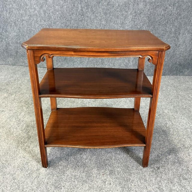 This vintage Grand Rapids side table showcases a classic traditional design with a softly shaped top, elegant apron...