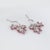 Stylish contemporary ruby & diamond maple leaf drop earrings crafted in 18k white gold. Diamonds total an estimated 0.50...