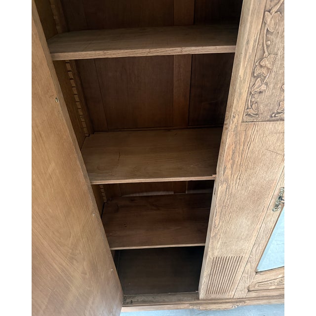 Large two-door wardrobe from the belle époque period (1900–1910). Its patinated oak, naturalistic carvings, and beveled...