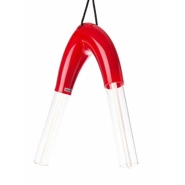 Two glowing glass tubes suspended from a single arched elastomer form — the biegung 02 redefines what a pendant light can...