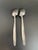 Set of 2 Mid-Century Modern CI stainless grapefruit spoons, featuring a central crease at the neck. Good condition with...