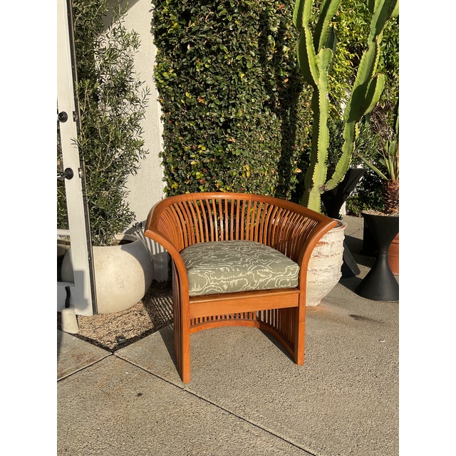 Vintage lounge chair with curved slat back and open arm design. Solid wood frame with vertical slat detailing wrapping the...