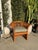 Vintage lounge chair with curved slat back and open arm design. Solid wood frame with vertical slat detailing wrapping the...
