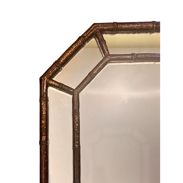 A lovely, vintage, faux bamboo mirror. Features an octagonal mirror with faux bamboo trim. Finished in a faux...