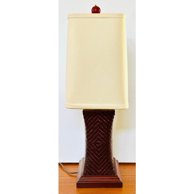 Beautifully woven deep cinnabar base of this table lamp is shaped in the style of an antique Asian pillow and topped with...