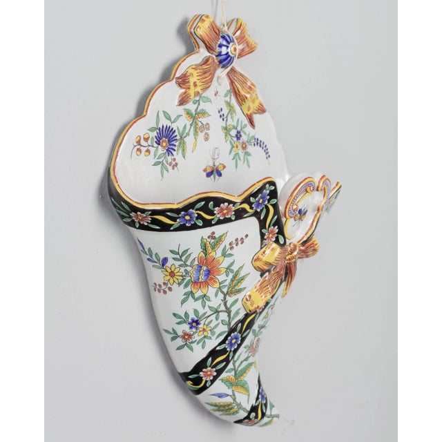 A 19th century French Desvres faience wall pocket, or cone shaped flower holder, with hand-painted floral decoration and...