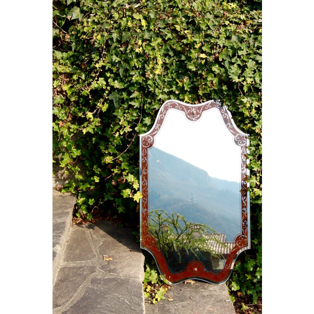 This elegant vintage mirror, crafted in Italy in the early 1960s, features a beautifully shaped frame in a rich burgundy...