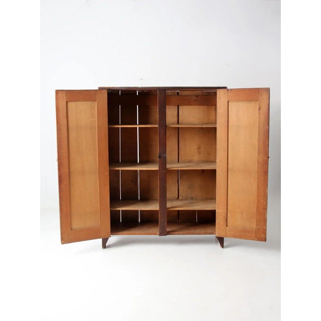This is an antique cupboard. The rustic cabinet features paneled double doors that open to four shelves. MEASUREMENTS...