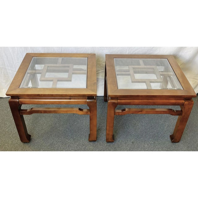 Simple and elegant pair of vintage Chinese Chippendale end tables from the 20th century. They are made of solid wood with...