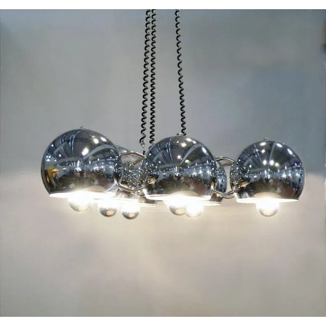 - Chandelier produced by Regginai, 70s - Chromed balls forming a triangle - Adjustable height, max 100 cm This piece is...