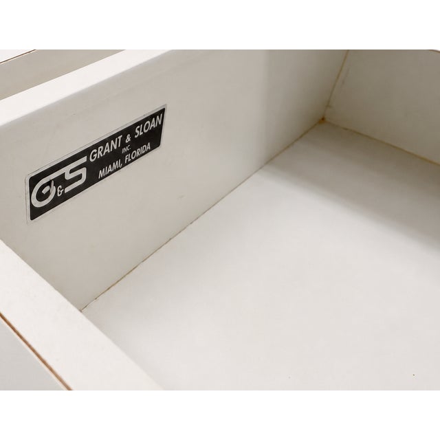 Vintage mirrored credenza by Grant & Sloan of Miami, Florida. It features a white laminate cabinet with four mirrored...