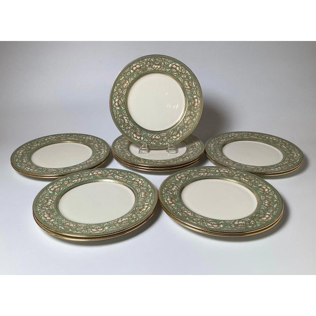 Elegant set of 12 gilt and sage green border service plates. The plates with a floral borders in green with gilt outline...
