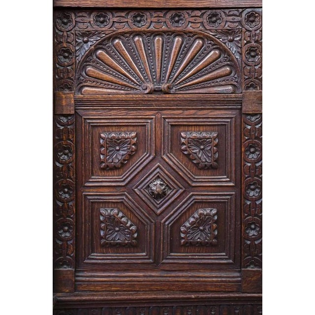 Solid oak cabinet decorated with hand-carved Renaissance style. Top glazed with height-adjustable shelves, bottom with one...
