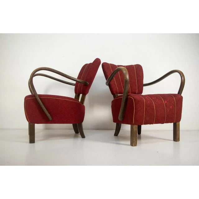 Rare most elegant version of H-237 armchairs designed by Jindrich Halabala in very good original condition. Dark red...