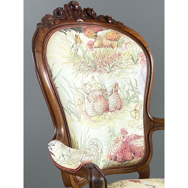 Elegant armchair with a finely carved solid wood frame, resting on four cabriole legs, two of which are fitted with...