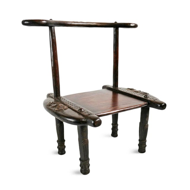 Antique carved Senufo tribal chair from Western Africa. Stylized rounded back with circular handles and traditional ram's...