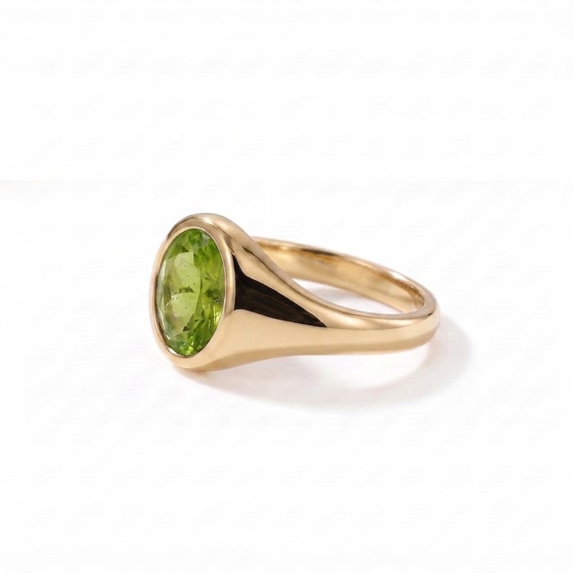 Bright and refreshing, this Natural Peridot Signet Ring features a vibrant 7 x 5 mm oval-cut peridot beautifully framed in...