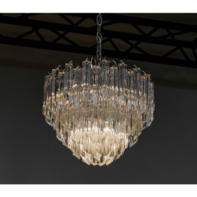 Beautiful chrome tiered chandelier attributed to Venini. The chandelier is filled with 91 clear Triedri Murano crystals...