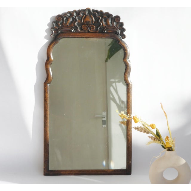 An antique original scalloped mirror made out of walnut. The wall mirror has a beautiful carved ornament on the top and a...