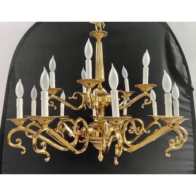 An majestic English Victorian-style brass chandelier, resplendent with fifteen gracefully articulated arms. The...