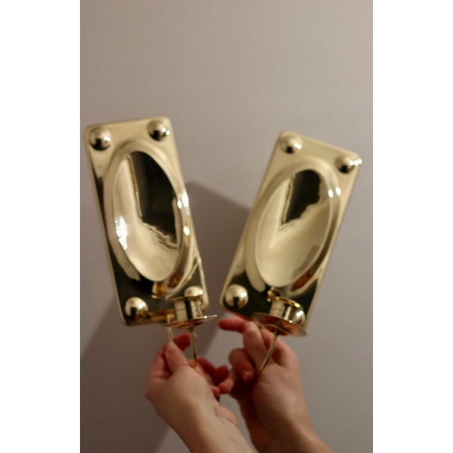 Made in Sweden. Two exquisite brass candle sconces from the Mid Century era, meticulously handcrafted with a stunning...