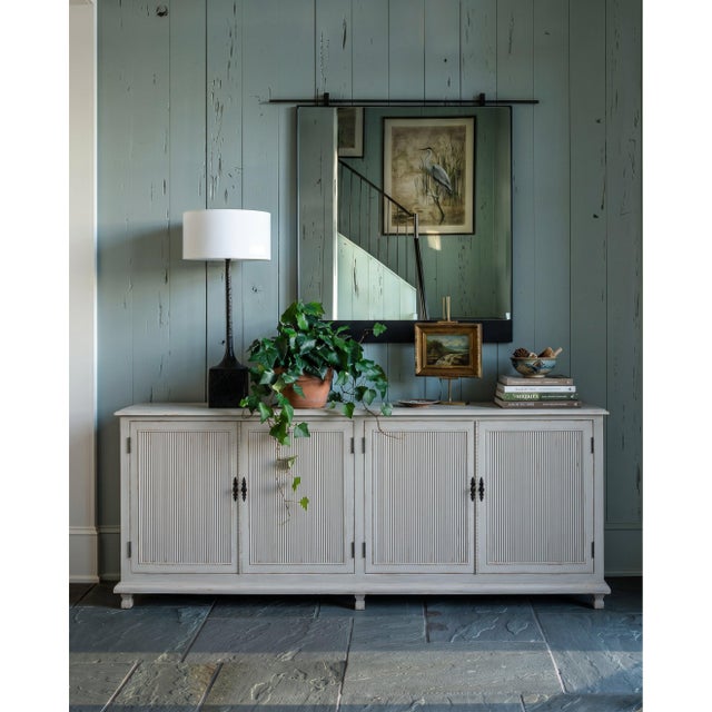 Fine parallel reeding spans every door across a 95-inch case, casting narrow shadows that change with the light. The soft...