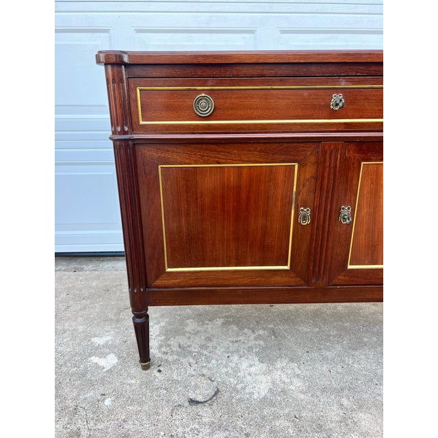 This elegant 19th-century French Louis XVI mahogany buffet features a rich mahogany finish, two paneled doors with...
