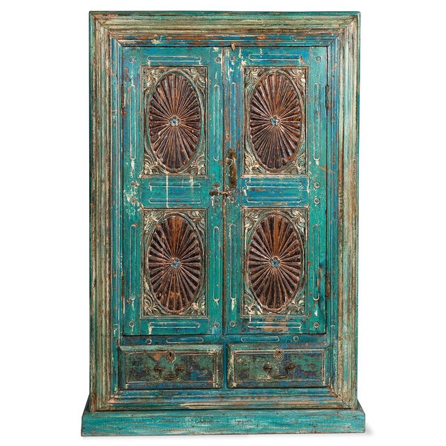 A striking Indian almirah cabinet from Gujarat, handcrafted from solid wood with beautifully weathered turquoise paint....
