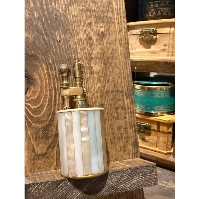 Tiffany & Co. Table Lighter, featuring a stunning mother of pearl iridescent paneled body and heavy brass lift arm...
