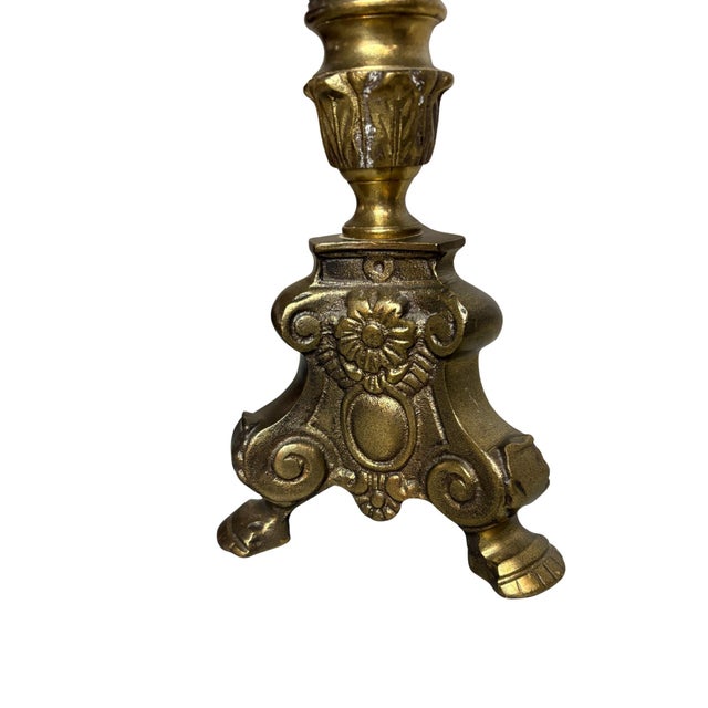 This antique brass candlestick features stunning Gothic styling with intricate detailing throughout the stem and base. The...