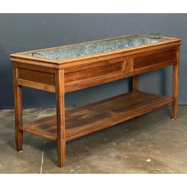 A fine French console jardiniere planter or plant stand table of cherry-wood with original metal liner, featuring a...