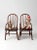 This is a pair of antique kid's chairs. The little wood arm chairs have turned spindle backs and legs. Lovely tone to the...