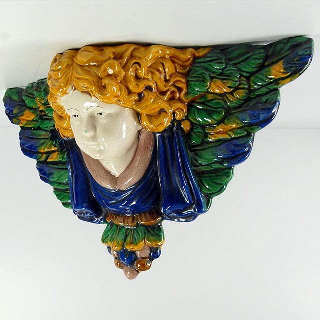 A very decorative head of a winged angel made of majolica. It is hand-painted and glazed with high gloss. It comes from...