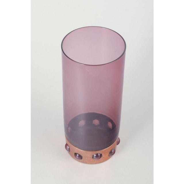Nanny Still for Raak Vase in purple glass and copper. Mid-20th century. A cylindrical vase in purple glass mounted in a...