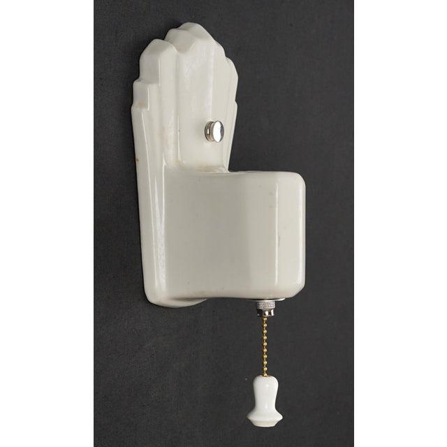 Art Deco style white porcelain wall sconce with a pull chain. This sconce requires one Edison style medium base bulb. Good...
