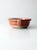 This is an antique pottery bowl with handles. The beautifully aged has a terra cotta tone glaze.