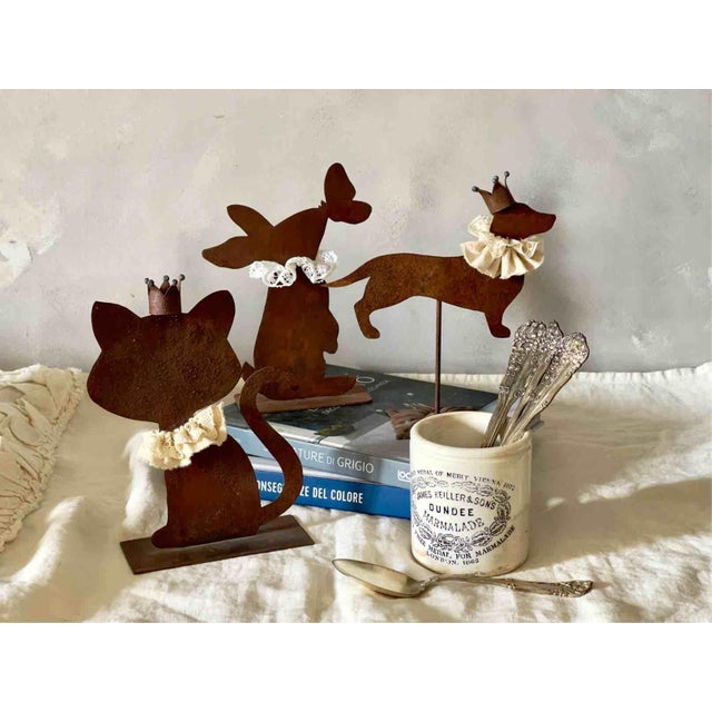 A set of three charming decorative figures for the home depicting a dachshund, a cat, and a rabbit. This triptych is made...