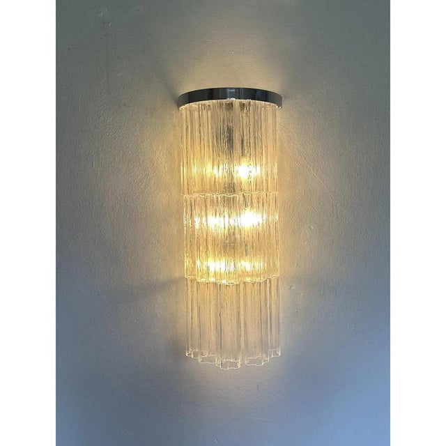 Luxury and scenographic wall sconces made in murano glass. three levels of murano glass “tronchi “ with a chromed belt ....