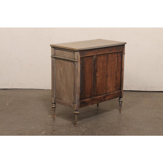 A charming French painted wood four drawer commode from the late 19th century. This antique chest from France, designed in...