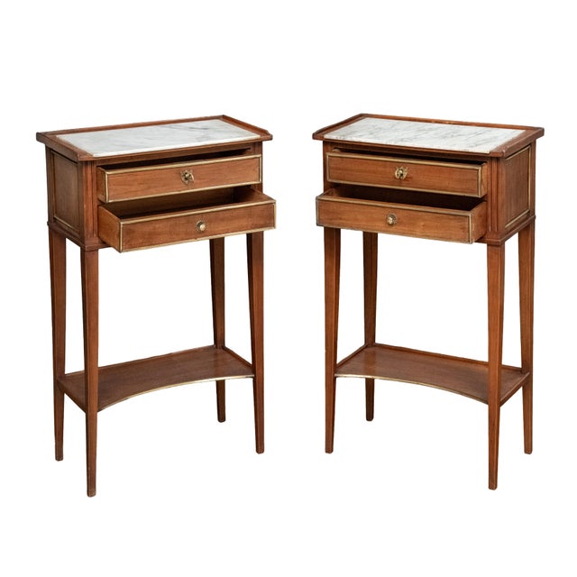 A fine pair of French bedside end tables or night stands - each stand on an elegant mahogany frame, featuring an inset...