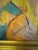 Two figures emerge from a wash of soft green, blue, pink, and ochre, one delicate and forward-facing with red lips and a...