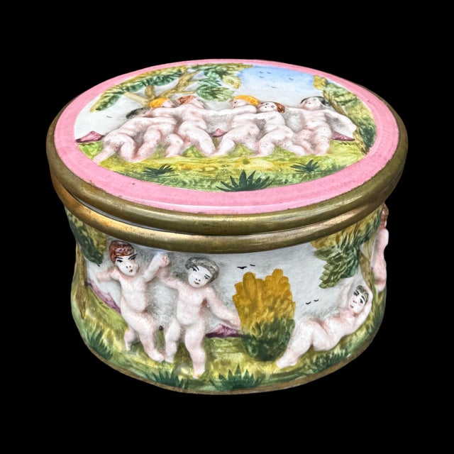 This vintage Italian porcelain trinket box is crafted in the Capodimonte style, known for its detailed high-relief...