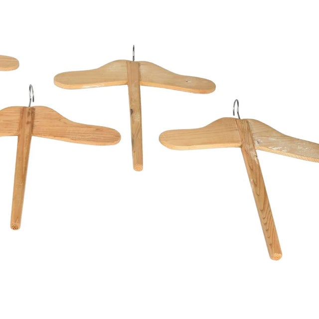 This set of four solid fir hangers was produced in Italy in the 1940s.
