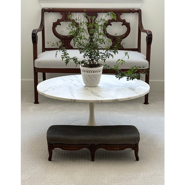 An elegant antique French low upholstered stool in solid walnut with beautifully shaped cabriole legs and a flowing...