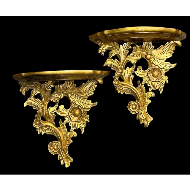 This is a pair of 1960s Hollywood Regsncy carved giltwood wall brackets. They are a nice large scale and a depict a floral...